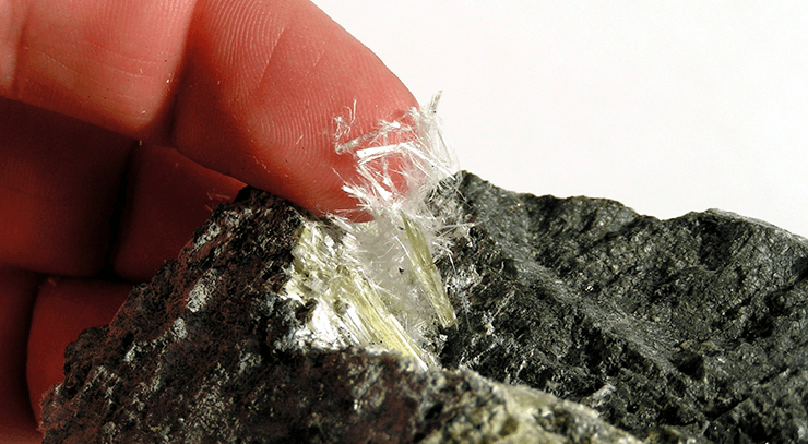 man touching asbestos fibers
